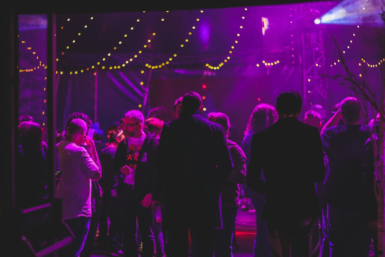 Image of an indoor party scene with purple light hue.
